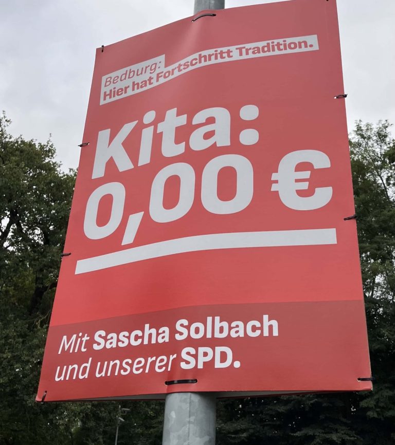 Wahlplakat der SPD Bedburg Weiße Schrift auf rotem Hintergrund: "Kita: 0 Euro"